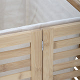 Close-up of the Aden Bamboo Laundry Basket's hinged lid corner, showing natural slatted bamboo panels, a metal hinge, and the cream cotton liner folded over the rim.