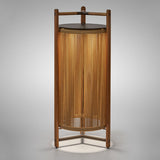 Kando P/111/R rechargeable outdoor floor lamp with sand nautical cord cylinder in a teak wood frame, brown top disc, and three-legged base, lit from within, on a plain light background.