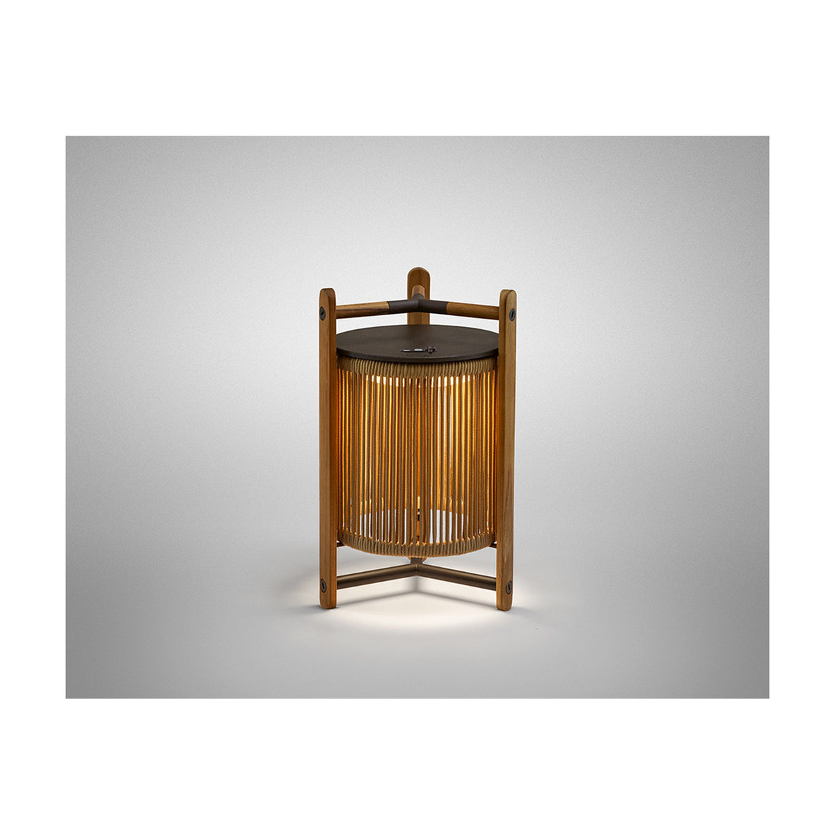 Kando M/40/R rechargeable outdoor table lamp with sand-coloured nautical cord cylinder, teak wood uprights, and dark top, shown lit against a plain light grey background.