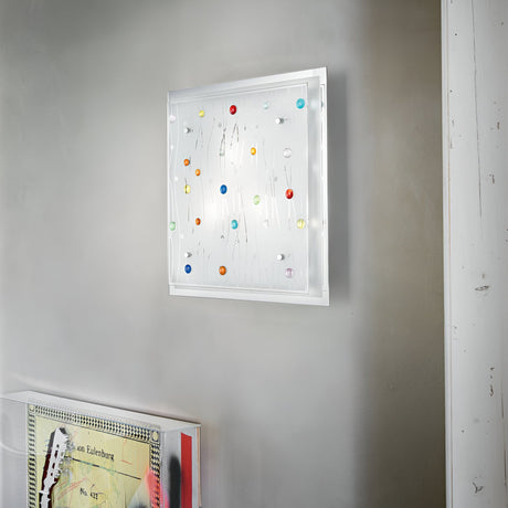 A contemporary art piece adorns the wall, showcasing a white background with vibrant, abstract shapes in shades of red, blue, yellow, and green. Dynamic lighting effects illuminate the artwork. Below it is a segment of another piece featuring geometric patterns in muted tones under the Horizon 3 Light Ceiling & Wall Light - Multicolour.