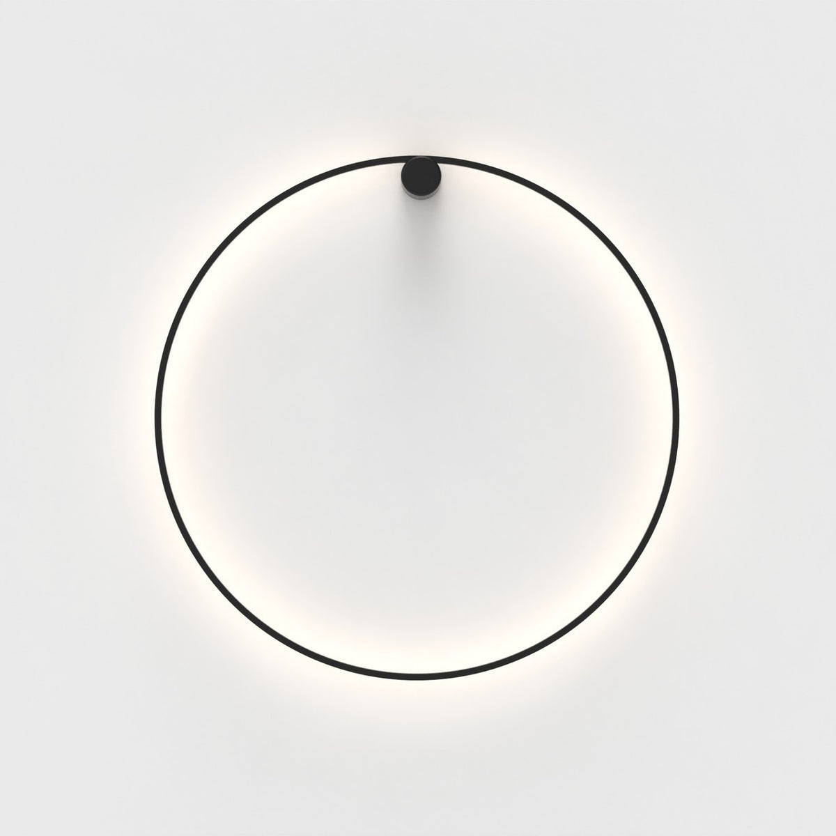 Ramona LED Wall Light in matt black, a thin circular ring with a round top mount, glowing warm white against a plain light background.