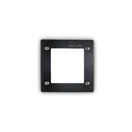 The Polar Recessed Square Outdoor Light - Black features a minimalist square black metal frame with four visible screws at each corner, surrounding a recessed white center. The words "The Impossible Project" are embossed at the top center of the frame. This UV-stabilized design is perfect for outdoor light settings and offers a sleek look against a white background.