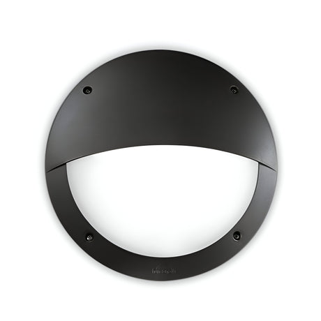 The Alfa LED Bulkhead - Black is a circular wall light fixture mounted on a white wall, featuring a design with a half-moon cover. Its minimalist and modern appearance is complemented by an IP66 Rating for durability.