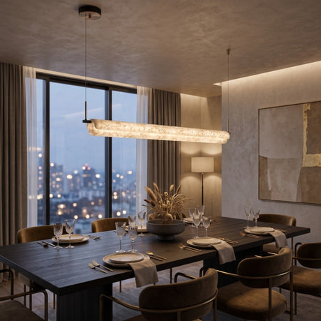 Anellara LED linear alabaster chandelier, 100cm horizontal bar with continuous veining, black canopy and dual cable suspension, shown above a dining table at dusk.