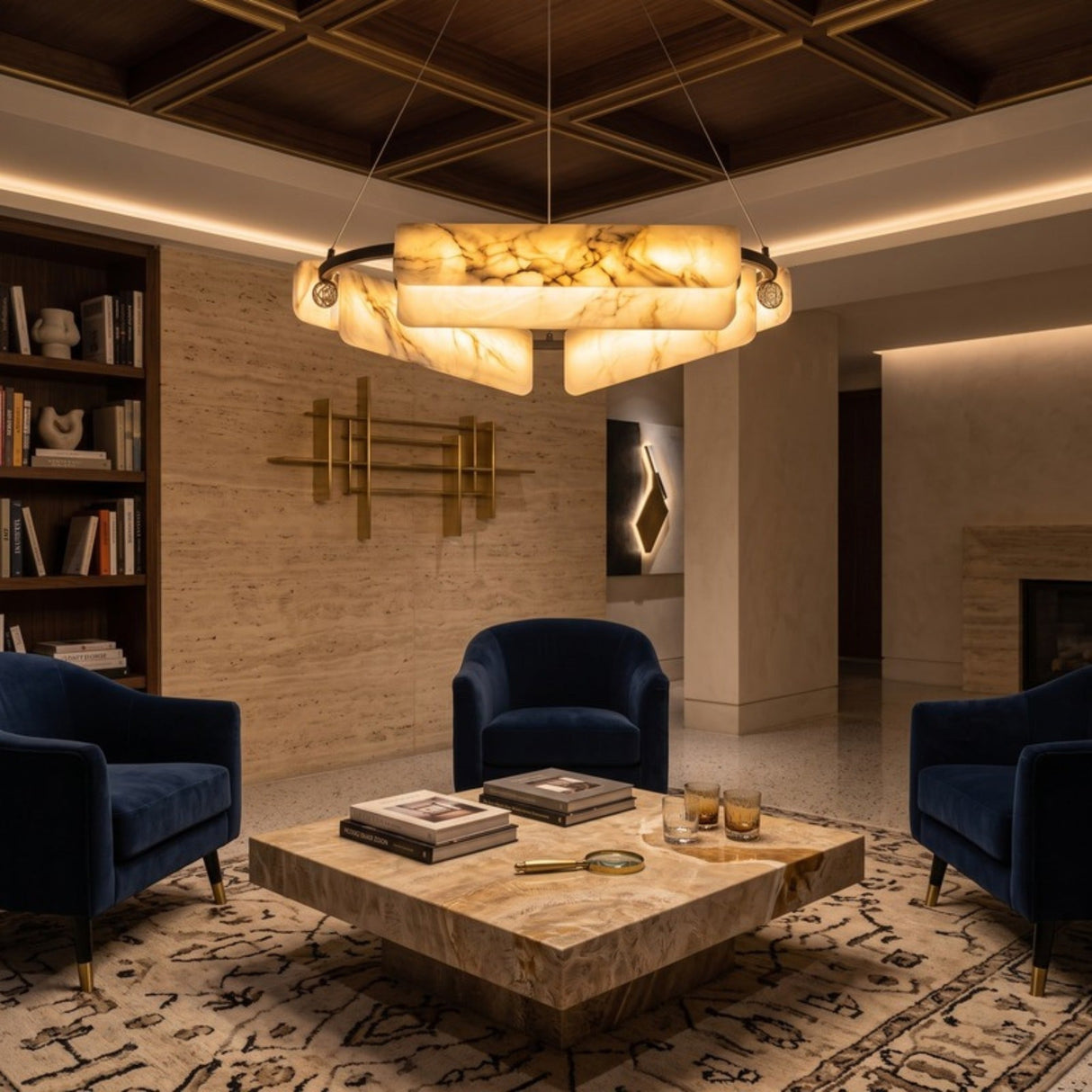 Anellara 60cm LED Radial Alabaster Chandelier in Black & White, a circular fixture with angled alabaster blocks glowing warmly above a living room with navy armchairs and a stone coffee table.
