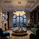 Anellara LED Radial Alabaster Chandelier 60cm, black ring with angled alabaster blocks and brass accents, shown above a living room seating area with city view.