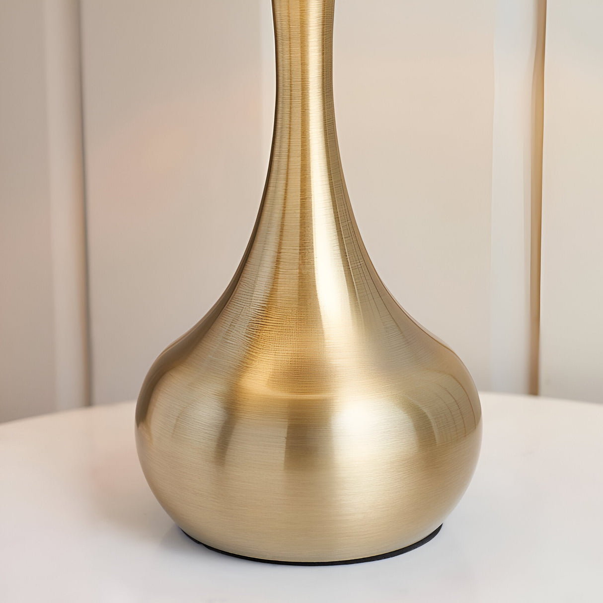 Endon Chartbury LED table lamp base in brushed brass with a curved teardrop shape, shown close-up on a white surface.