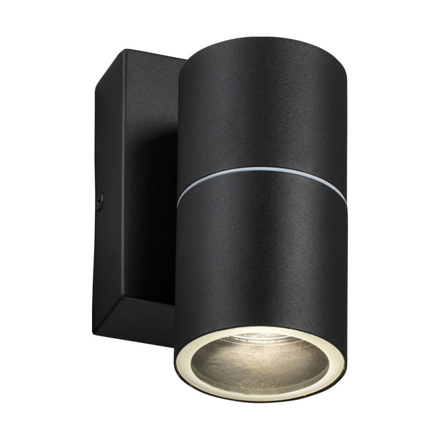 A contemporary cylindrical stainless steel outdoor wall light fixture in black, designed with a photocell sensor and emitting light from the bottom.