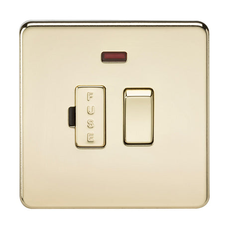 The 13A Switched Fused Spur Unit Neon - Polished Brass (Screwless) is an elegant electrical switch with a polished brass finish. It features a fused spur, complemented by a fuse indicator and a small red light positioned above it on a square plate. This sleek, screwless design is low profile, combining elegance with functionality. The word "FUSE" is labeled vertically on the unit.