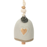 Grey ceramic hanging bell decoration with a gold heart on the front, sandy speckled rim, wooden clapper, and a metal heart charm and beads on the cord, shown on a white background.