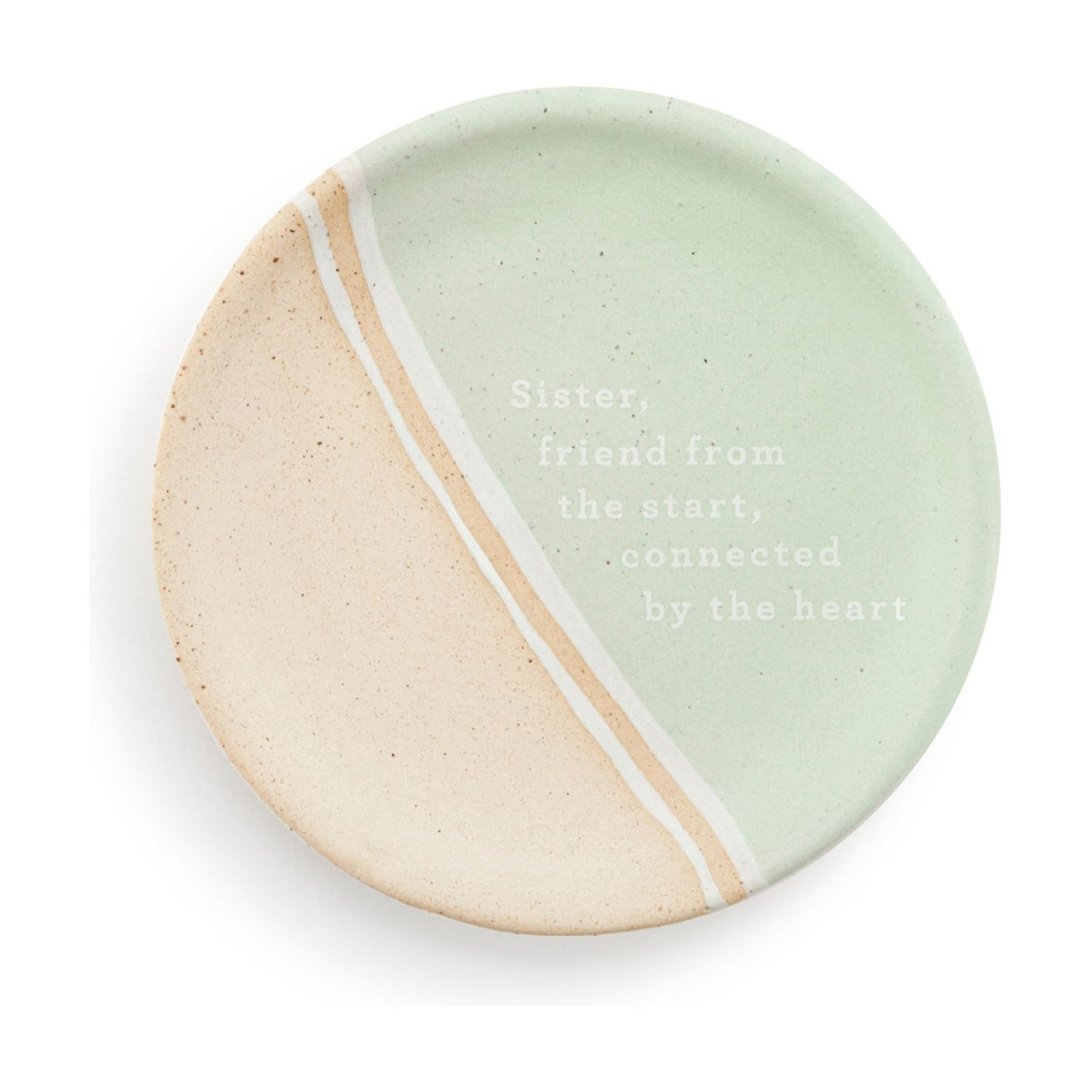 Round ceramic trinket dish in mint green and speckled beige with a diagonal white and beige striped divide, printed "Sister, friend from the start, connected by the heart", on a white background.