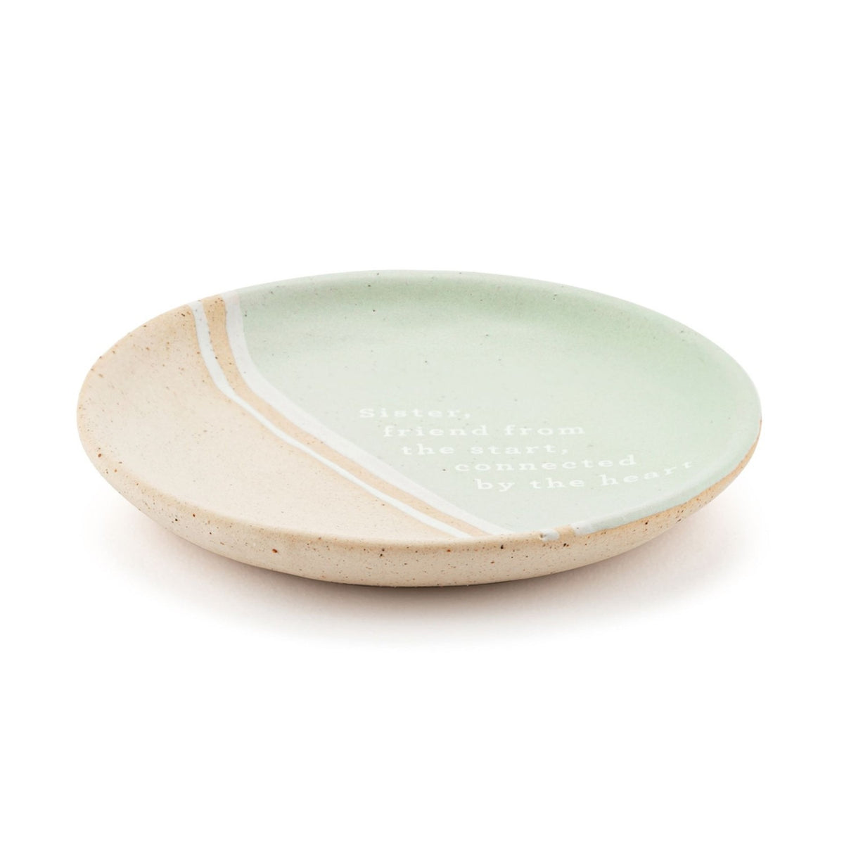 Round ceramic trinket dish in mint green and speckled beige with diagonal stripes, printed with the verse Sister, friend from the start, connected by the heart.
