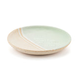 Round ceramic trinket dish in mint green and speckled beige with diagonal stripes, printed with the verse Sister, friend from the start, connected by the heart.