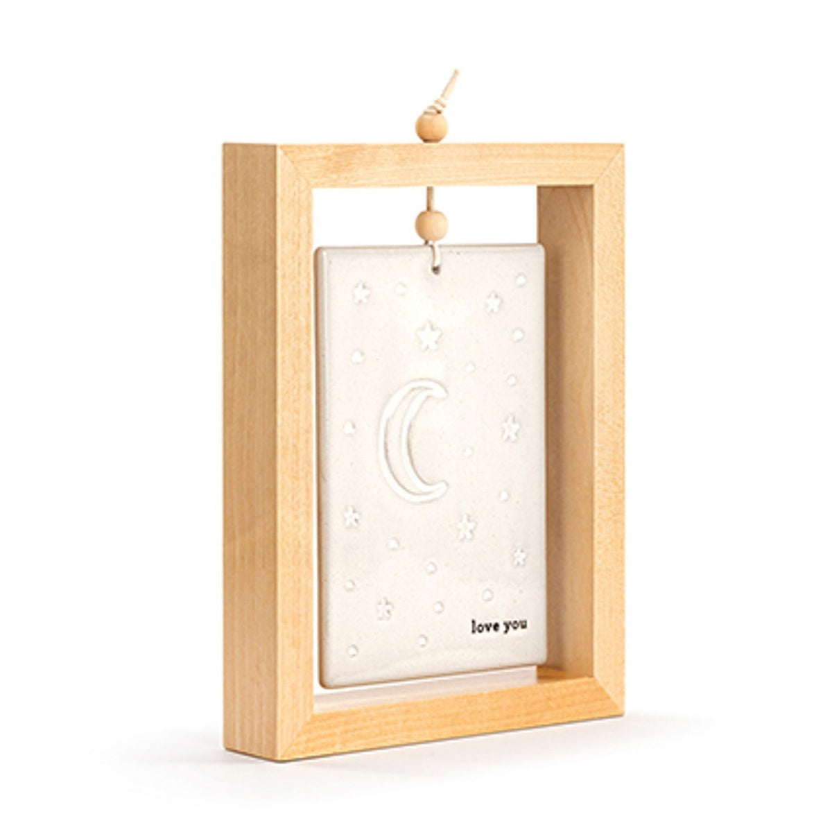 Standing plaque in an open wood frame with a hanging bead cord, holding a stone-coloured ceramic tile embossed with stars and a crescent moon above "love you" text, shown on a plain white background.