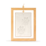Four Paws Standing Ceramic Plaque in a brown wood frame with a hanging cord, showing a stone-coloured tile with two raised paw prints and a small heart detail on a white background.