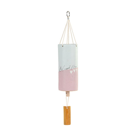 Ceramic wind chime with pale grey upper half and soft pink lower half, "Blessed Mum" script and three white hearts, hung on cords with a wooden clapper, shown on a white background.