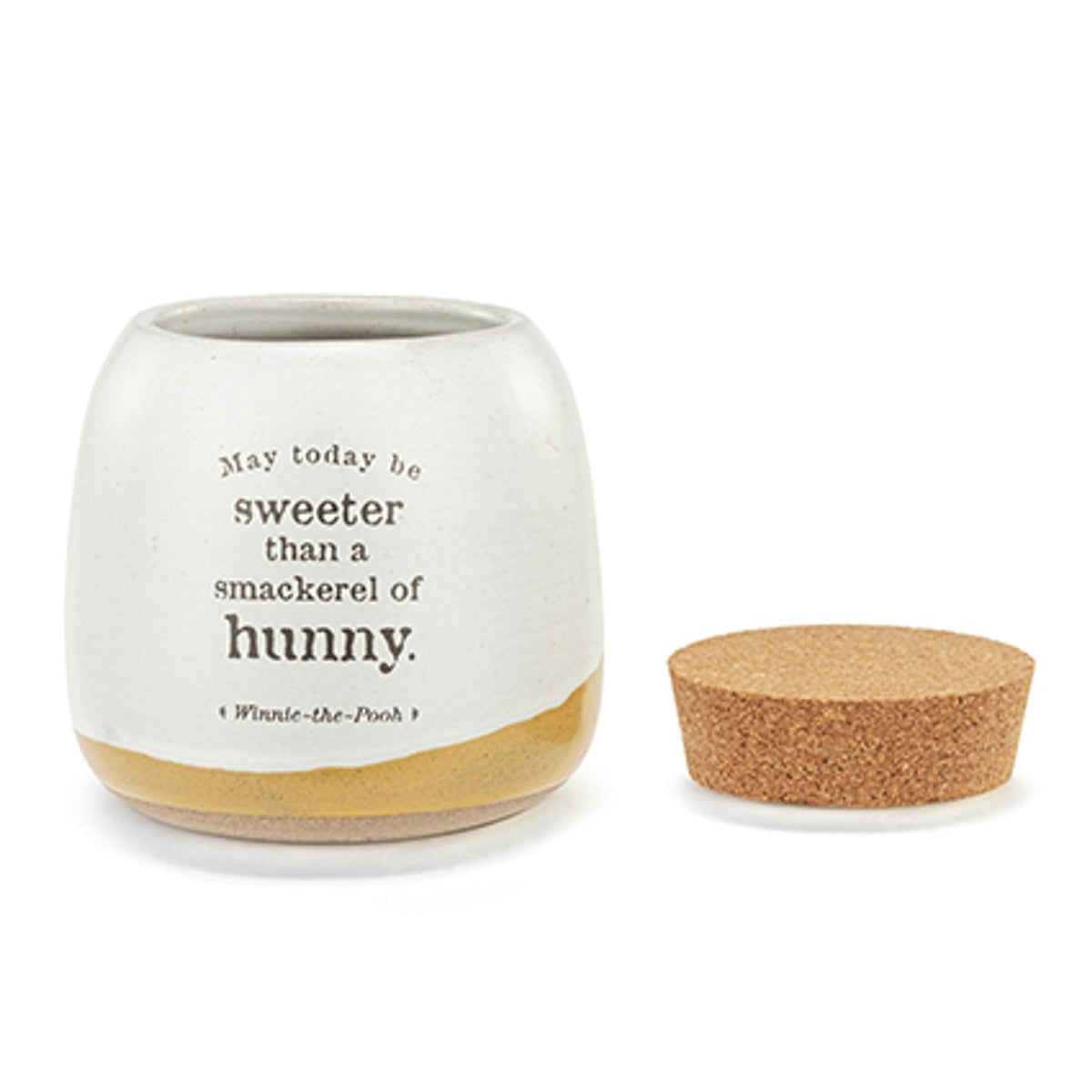 Small ceramic storage jar in stone glaze with mustard-yellow band, printed "Sweeter Than Hunny" Winnie-the-Pooh quote, shown with its round cork lid on a white background.