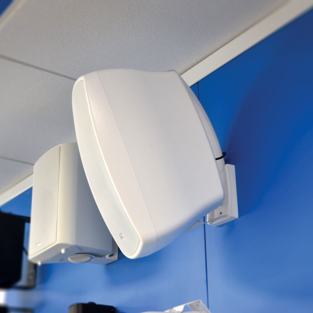 Adastra BH8-W white indoor/outdoor background speakers by AVSL, wall-mounted on tilt brackets against a blue wall below a white ceiling.