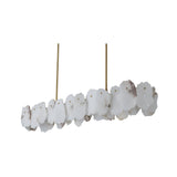 The Solvane LED Small Petal Alabaster Linear Suspension Light in Soft White & Brass features irregular alabaster-like pieces arranged in a row, suspended from the ceiling by two slim brass rods for a modern look.