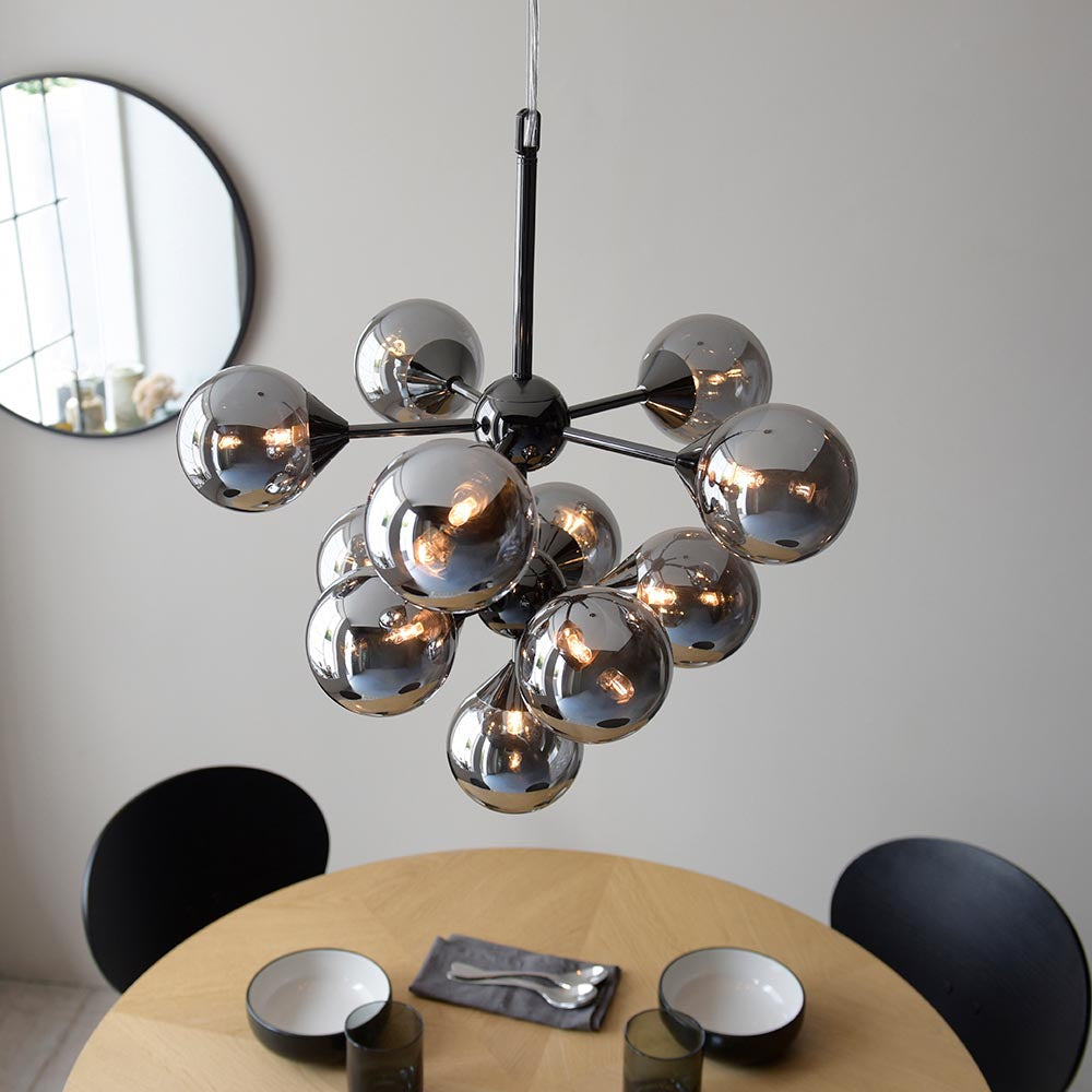 Endon Fitzroy 11 Light Pendant in chrome and black with smoked mirror glass globes on slim arms, hanging above a wooden dining table.