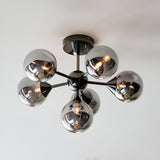 Endon Fitzroy 6 light semi-flush ceiling light in black chrome with six smoked glass globes on angled arms, mounted to a white ceiling.