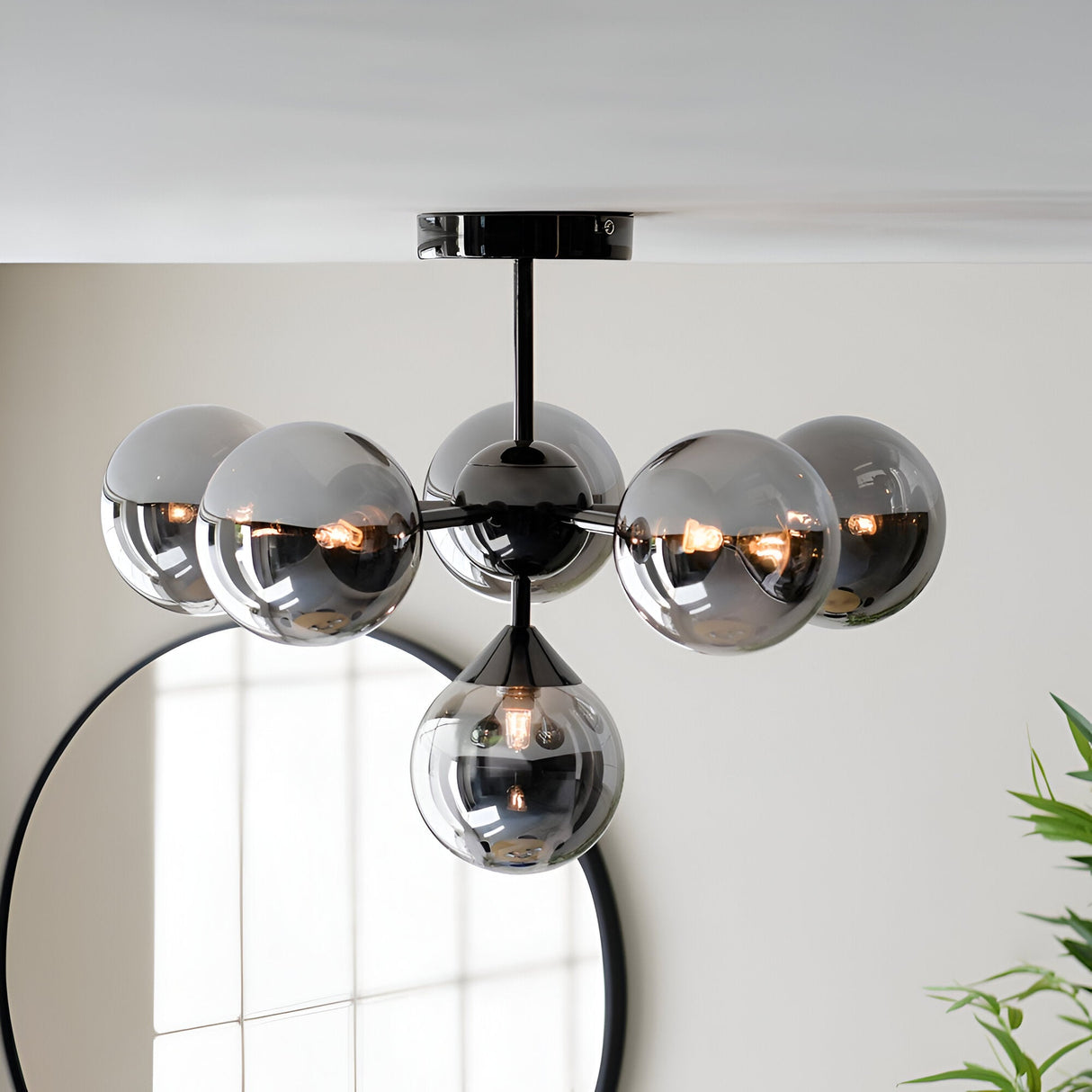 Endon Fitzroy 6 light semi-flush ceiling light in black chrome with smoked glass globes, mounted above a round black-framed mirror.