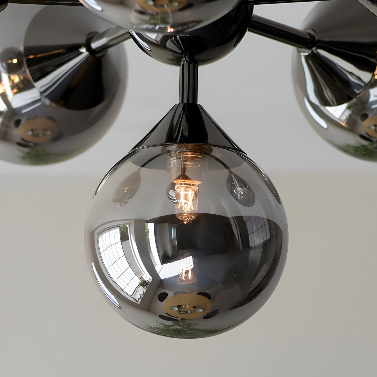Close-up of Endon Fitzroy 6 Light Semi-Flush Ceiling Light in black chrome, showing mirrored glass globe shades with illuminated G9 lamp.