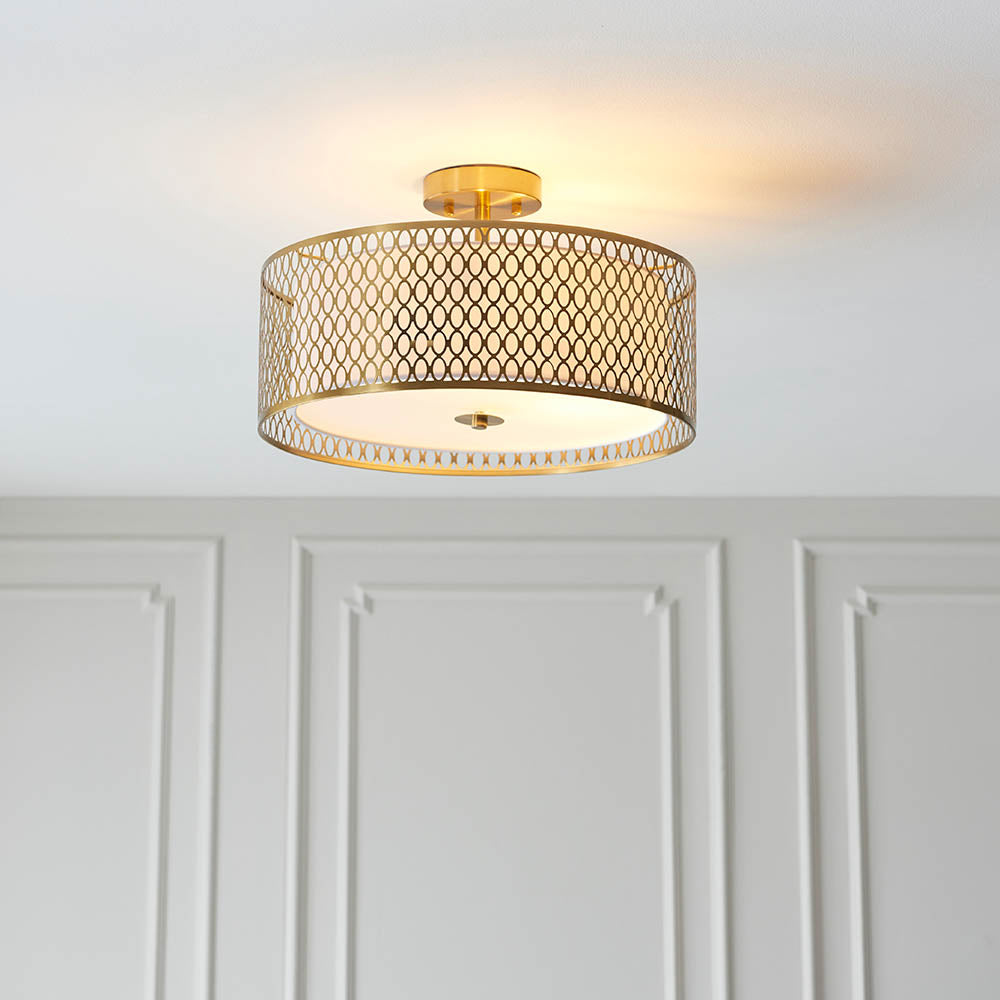 Endon Rosaline 3 light flush ceiling light in gold, drum shade with patterned metal lattice and diffuser, mounted on a panelled hallway ceiling.