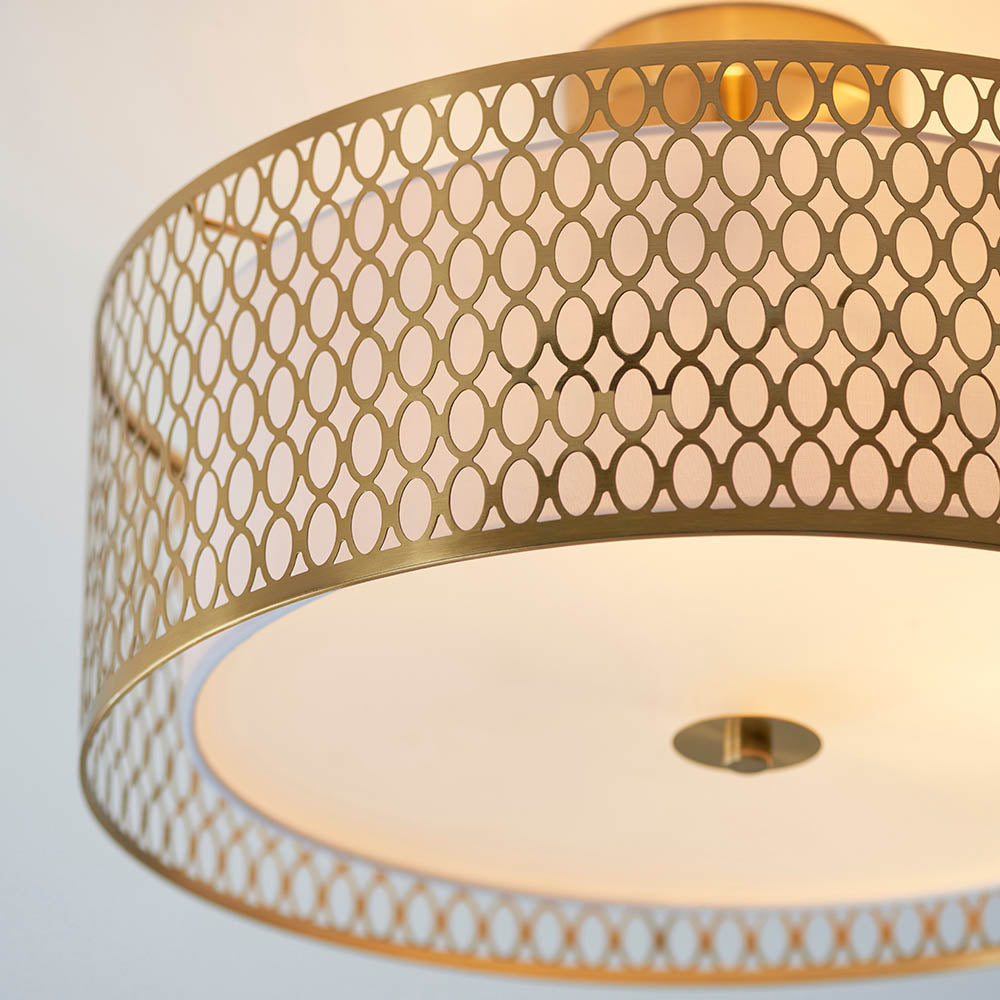 Endon Rosaline 3 Light flush ceiling light in gold, close-up of the drum shade's circular cut-out metal pattern with fabric lining and glass diffuser.