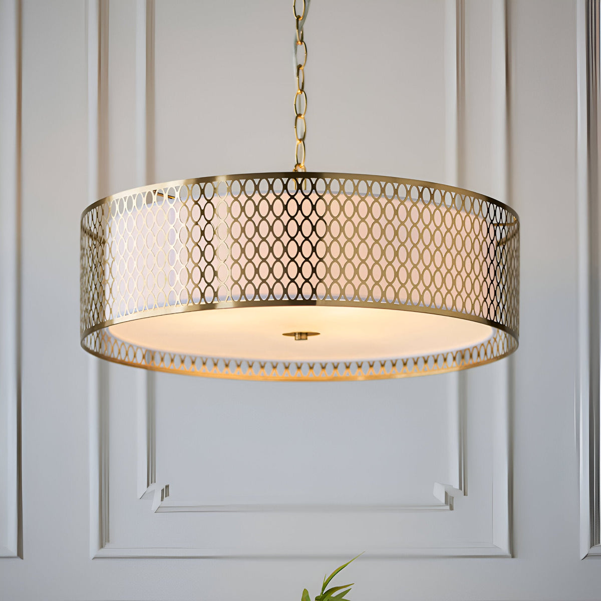 Rosaline 3 Light Pendant in gold fretwork with white fabric inner shade and frosted glass diffuser, hung on a chain against a panelled wall.