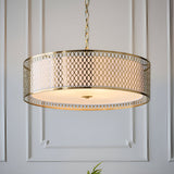 Rosaline 3 Light Pendant in gold fretwork with white fabric inner shade and frosted glass diffuser, hung on a chain against a panelled wall.
