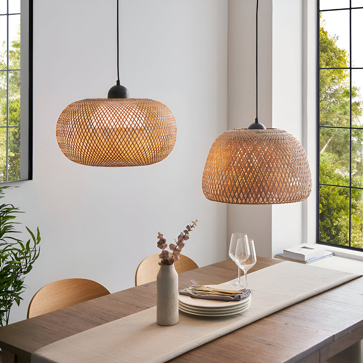 Endon Aldstead woven rattan globe and dome pendant lights with matt black fittings, suspended above a wooden dining table beside a large window.