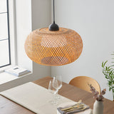 Endon Aldstead globe pendant in natural woven rattan with matt black ceiling fitting, illuminated above a wooden dining table by a bright window.