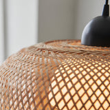 Close-up of the Endon Aldstead Globe Pendant showing its woven natural rattan shade and matt black ceiling fitting with warm light glowing through the weave.
