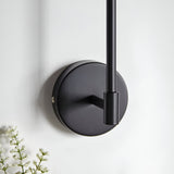 Endon Cliffhurst wall light mounting detail showing the matt black circular backplate and slim upright rod against a white wall.