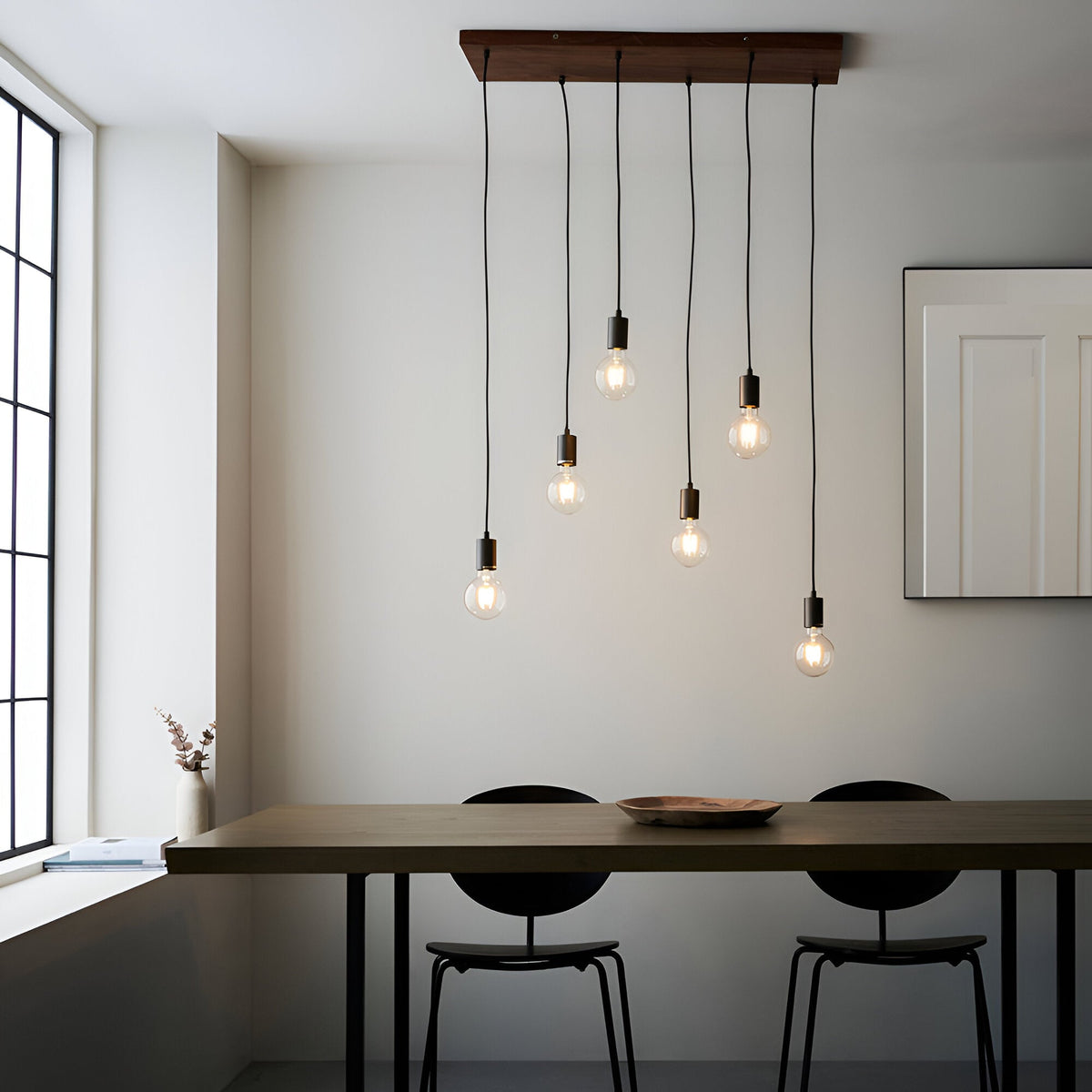 Endon Cliffwell 6 light linear pendant with natural oak plywood bar and anthracite lampholders on filament bulbs, hung above a wooden dining table.
