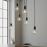 Endon Cliffwell 6 light cluster pendant with clear globe filament bulbs on black flexes and anthracite lampholders, above a dining table by a window.
