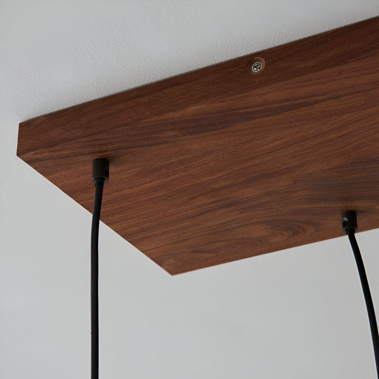Close-up of Endon Cliffwell linear pendant showing the oak stained plywood ceiling plate with black flex cables descending from anthracite lampholders.