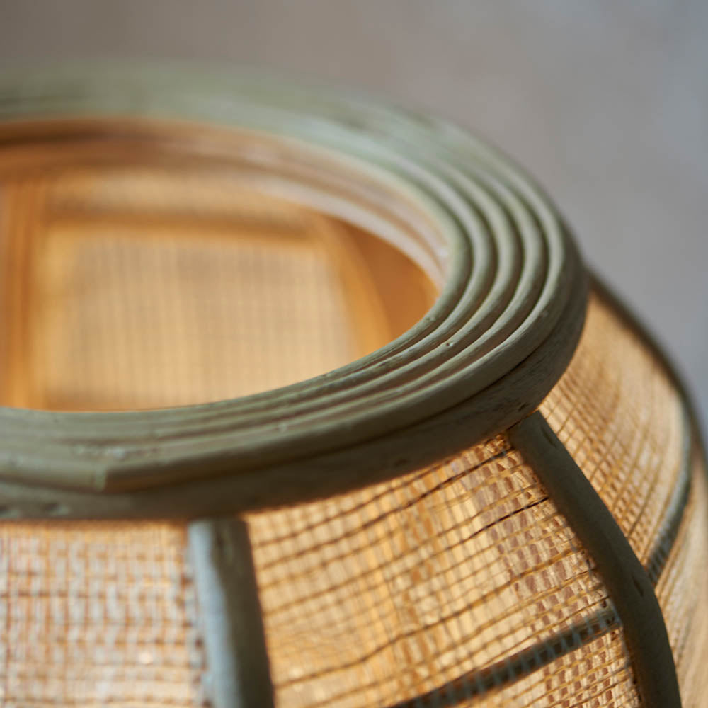 Close-up of the Endon Daneshaw table lamp showing its handmade woven bamboo and natural linen shade edged with a matt black metal rim.