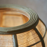 Close-up of the Endon Daneshaw table lamp showing its handmade woven bamboo and natural linen shade edged with a matt black metal rim.