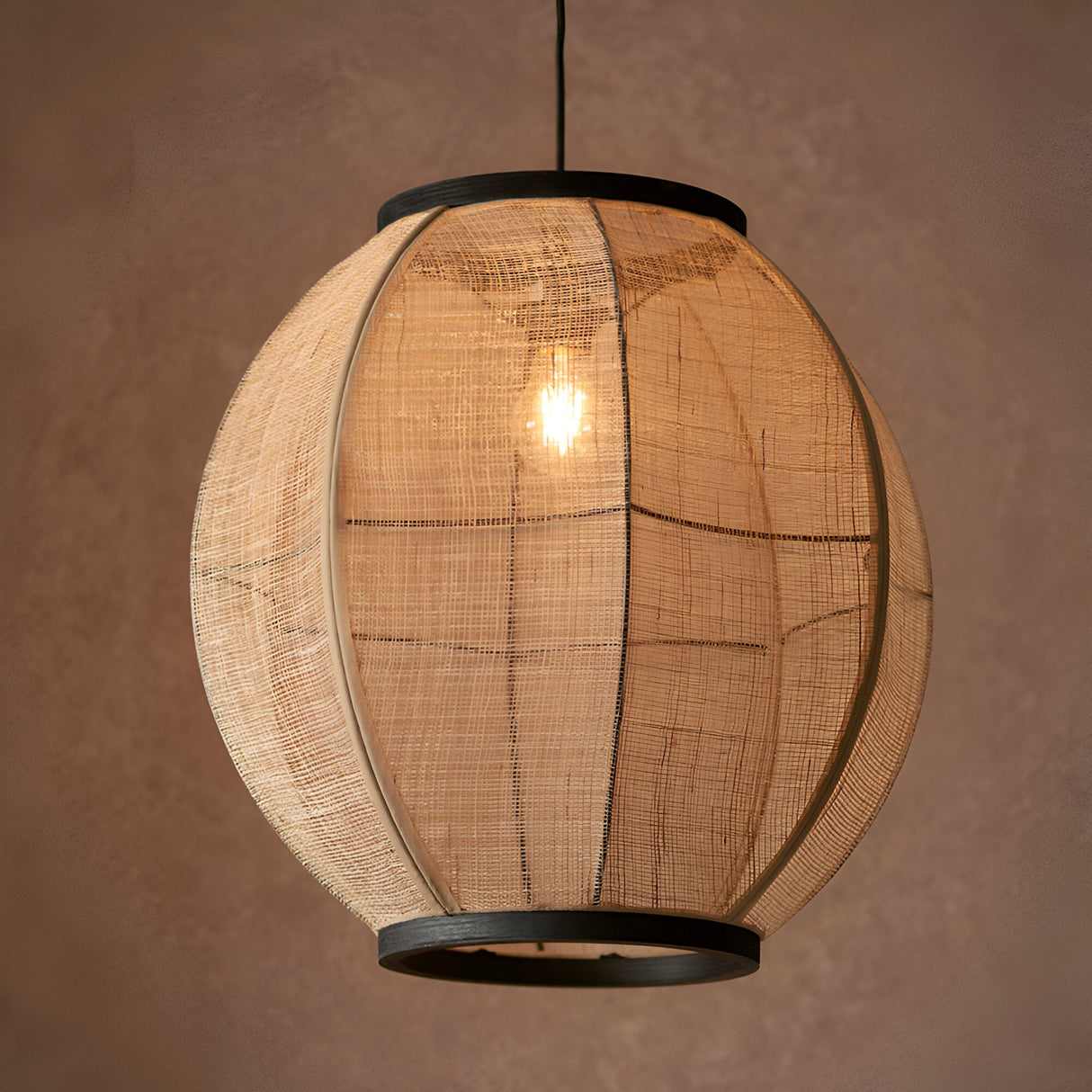 Daneshaw Pendant Light in Black & Natural, a spherical natural linen fabric shade with matt black metal trim and visible E27 bulb, on a plain brown background.