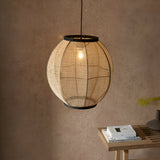 Daneshaw Pendant Light in black and natural, a spherical woven linen shade with matt black trim, shown lit above a wooden side table.