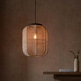 Endon Daneshaw pendant with handmade linen shade and matt black metalwork, lit by an E27 bulb, above a wooden console against a warm plaster wall.