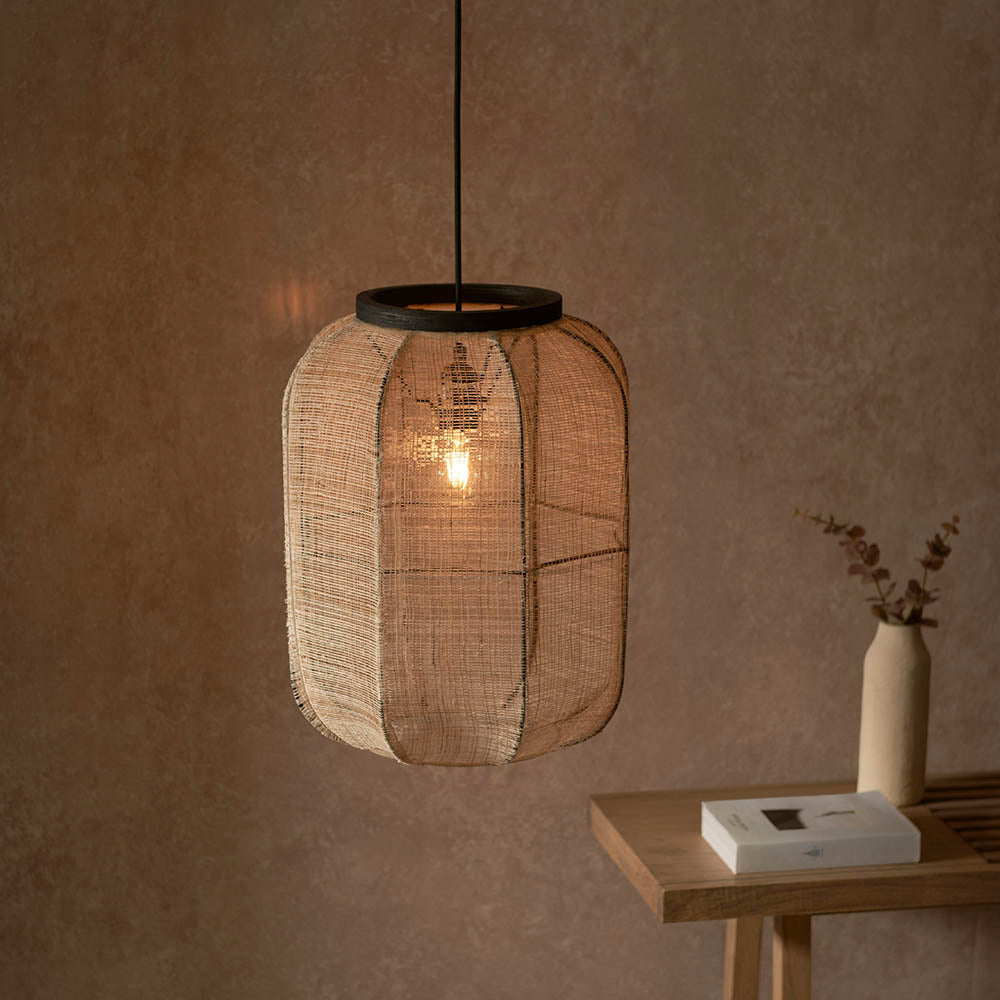 Endon Daneshaw pendant with handmade natural linen shade and matt black metalwork, lit with an E27 bulb above a wooden console in a warm earthy room.