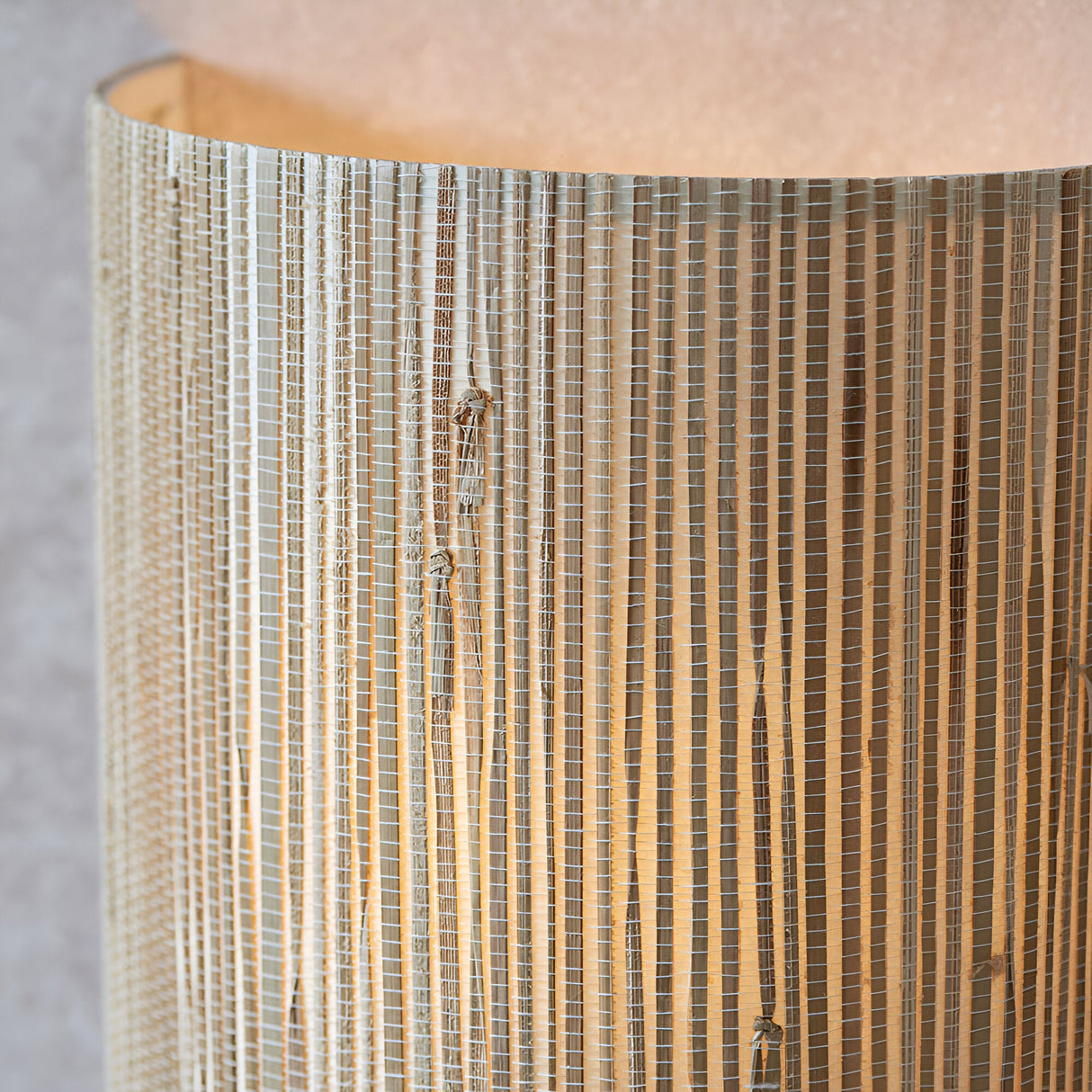 Close-up of the Endon Salcombe wall light showing the woven natural seagrass half-cylinder shade with visible texture and soft warm glow.