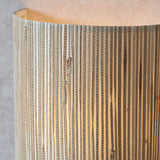 Close-up of the Endon Salcombe wall light showing the woven natural seagrass half-cylinder shade with visible texture and soft warm glow.
