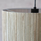 Close-up of the Salcombe Pendant Light's woven natural seagrass drum shade with matt black fitting and cable, against a light background.