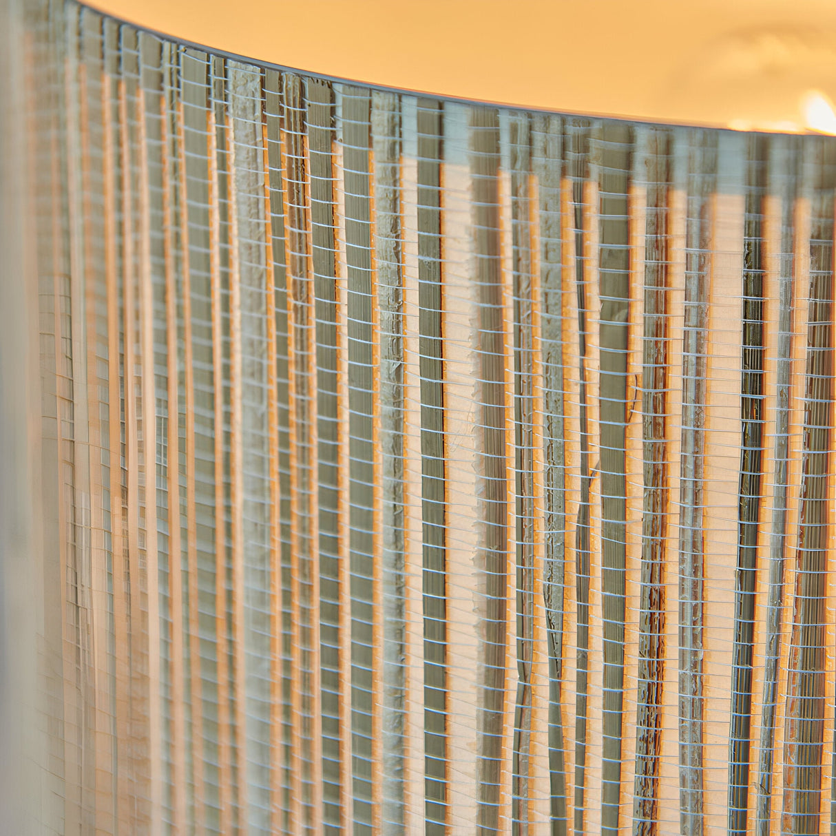 Close-up of the Salcombe Table Lamp's natural woven seagrass drum shade, showing vertical fibres and warm glow from the E27 bulb inside.