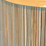Close-up of the Salcombe Table Lamp's natural woven seagrass drum shade, showing vertical fibres and warm glow from the E27 bulb inside.