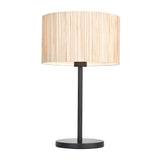 Salcombe Table Lamp with a natural woven seagrass drum shade on a matt black metal stem and round base, set against a plain white background.